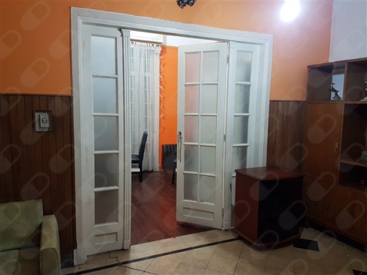 Sector de recepción con asientos y puerta de acceso al consultorio.